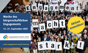 Eine große Gruppe hält Plakate mit den Buchstaben der Aktionswoche in die Kamera