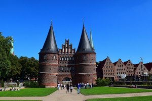 Zu sehen ist das Holstentor in Lübeck an einem sonnigen Tag im Sommer.