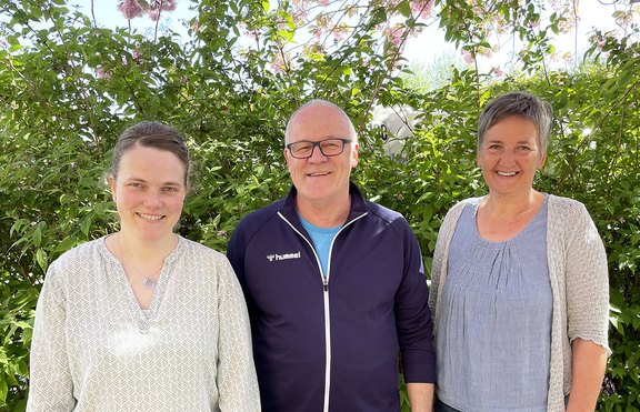 Auf dem Foto zu sehen sind zwei Frauen und in der Mitte ein Mann. Sie lächeln in die Kamera; es sind die Anprechpartner im Amt Hürup.