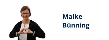 Das Foto zeigt Maike Bünning in dunkler Jacke und weißem Top, die mit den Händen ein Herz formt und in die Kamera lächelt.